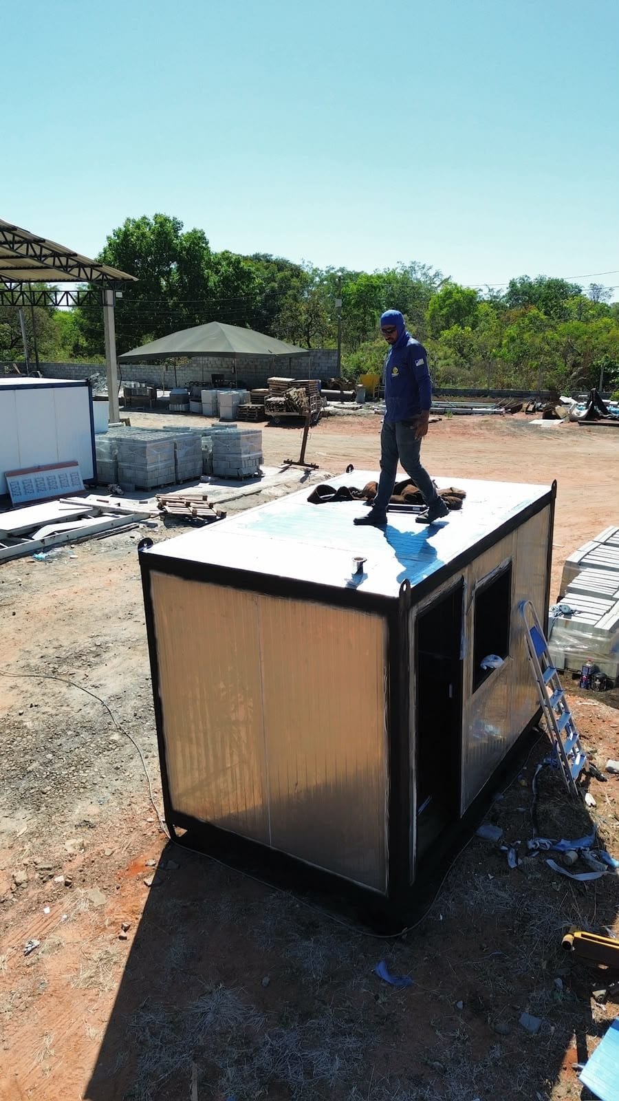 Funcionário da Moreira Container finalizando a cobertura de um container escritório no pátio de produção em Araguaína