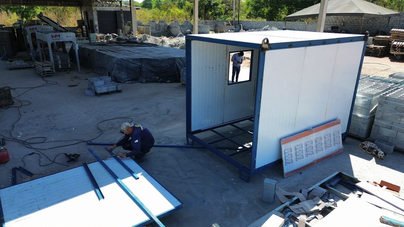 Funcionário da Moreira Container cortando painéis ao lado da estrutura metálica de um container escritório em montagem no pátio de Araguaína