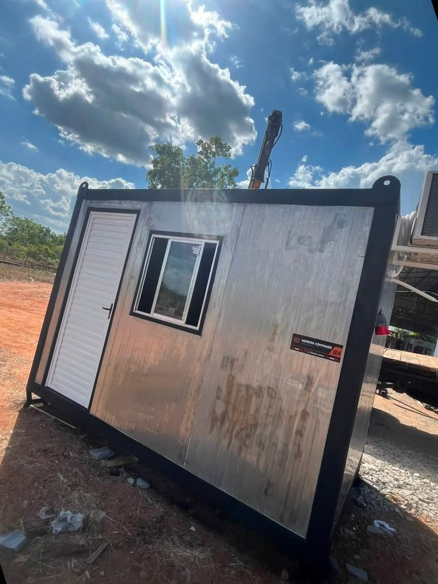 Container escritório da Moreira Container com porta e janela instaladas, posicionado por caminhão munck antes da entrega