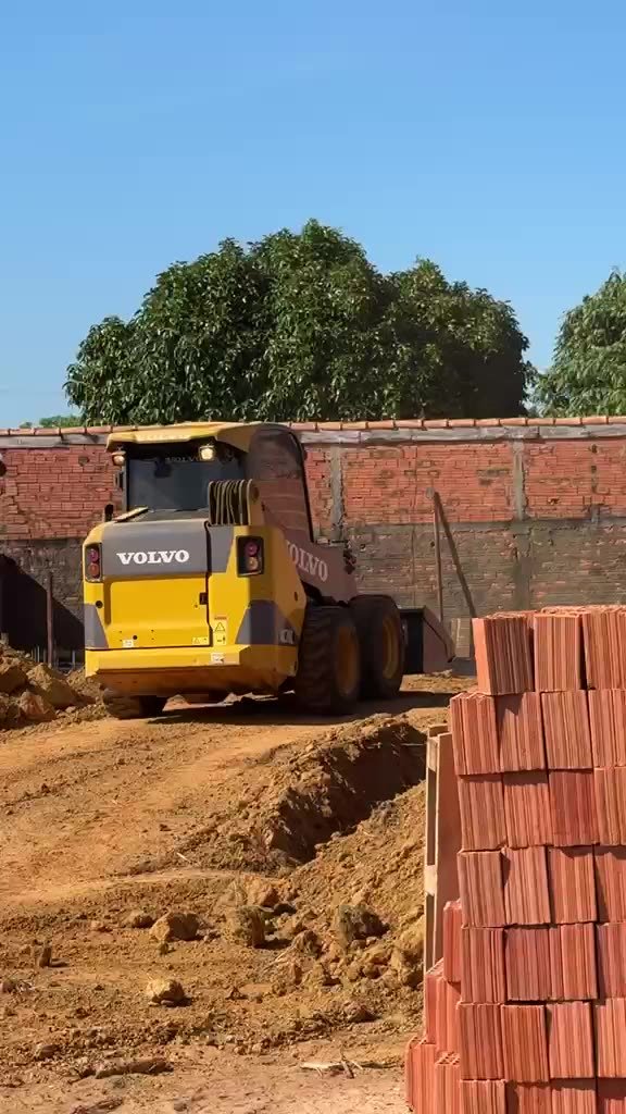 Minicarregadeira Volvo MC70C movimentando material em obra