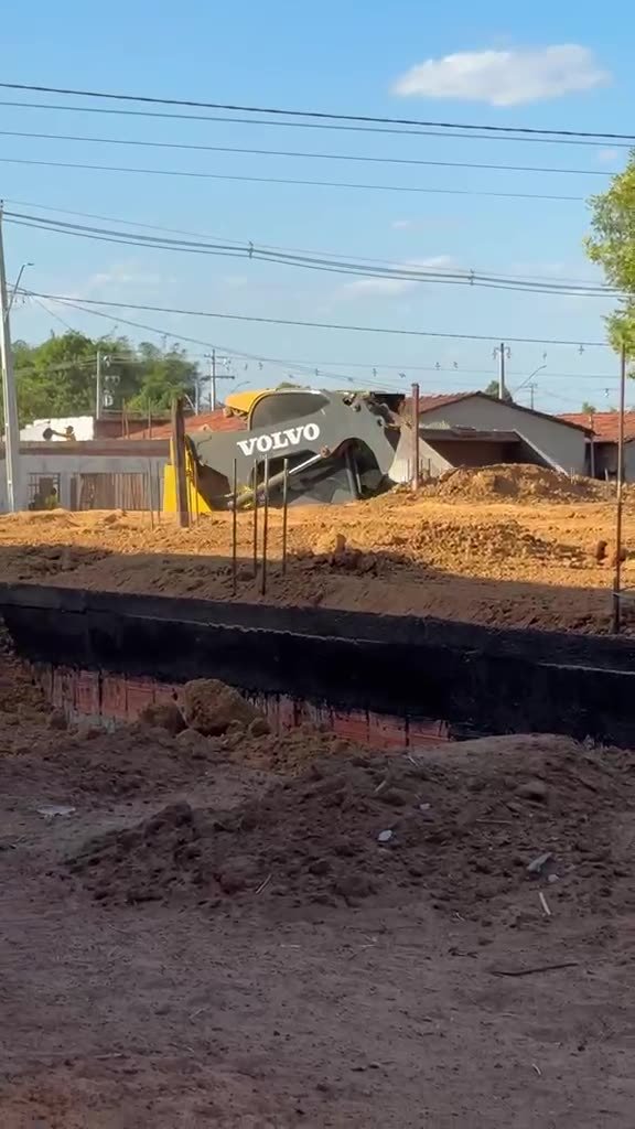 Minicarregadeira Volvo MC70C nivelando terreno de obra