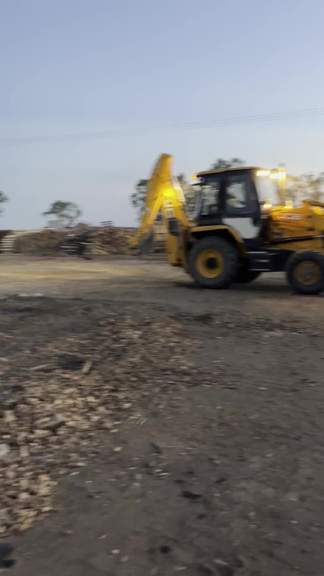 Retroescavadeira JCB carregando caminhão em obra