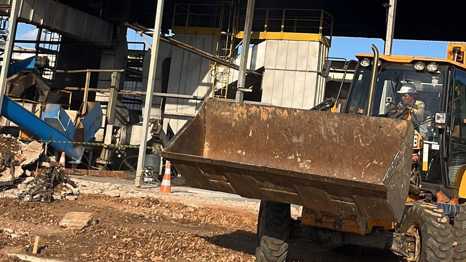 Retroescavadeira JCB em operação com a concha erguida