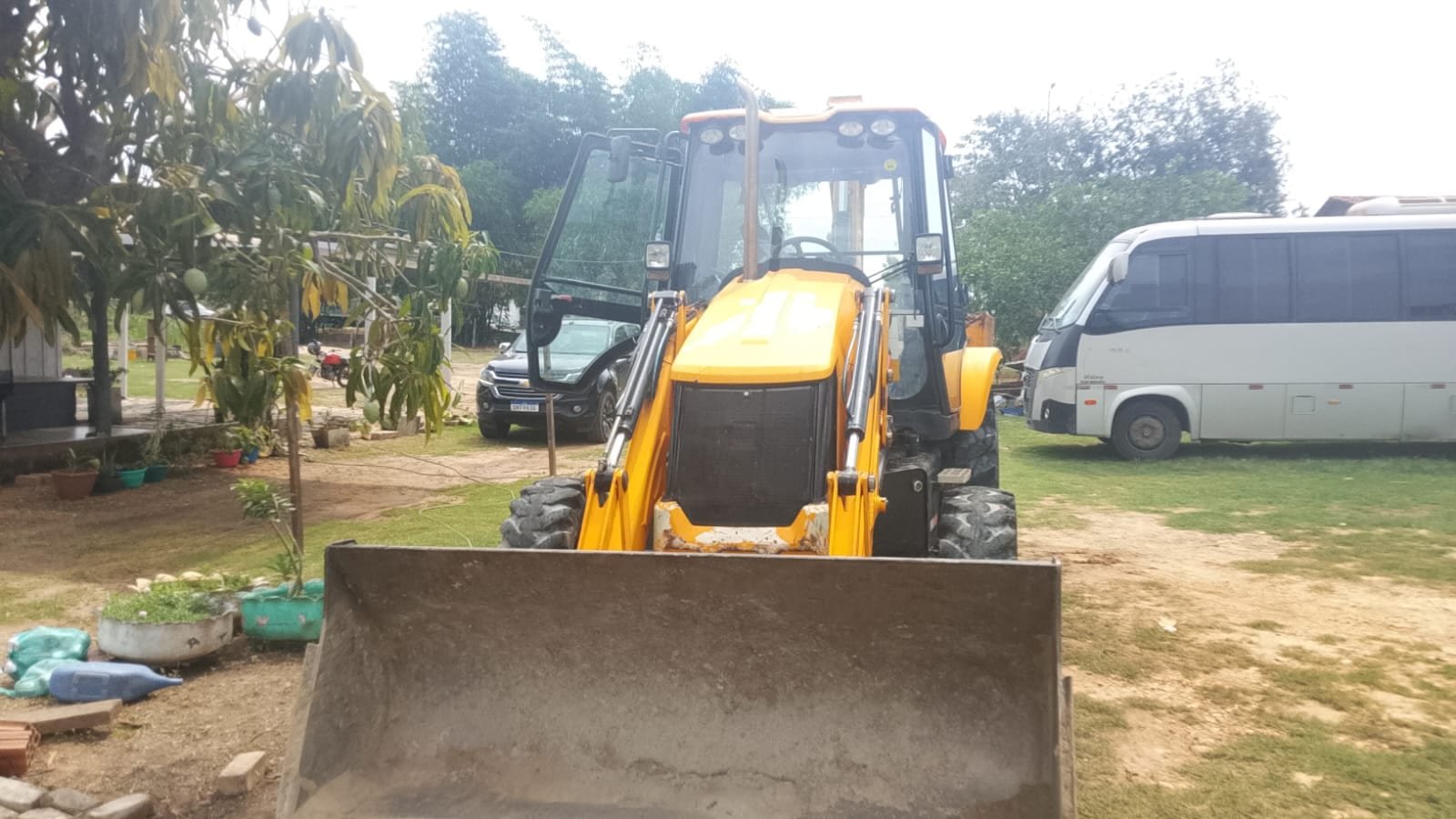 Retroescavadeira JCB de frente, com a concha carregadeira